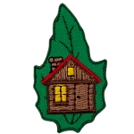 A cabin with a lit window is on a green leaf.