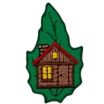 A cabin with a lit window is on a green leaf.