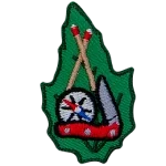 This leaf-shaped patch displays (from top to bottom) crossed matched sticks, a compass, and a pocket knife.