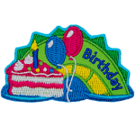 A green and yellow sea serpent hump with the word Birthday on it, and a piece of cake with balloons on the left.