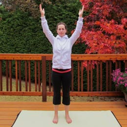 A girl stands with her arms raised.