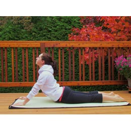 A girl laying down with her torso curved to the sky.