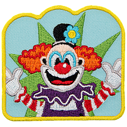 A happy clown with bright orange hair and his arms outstretched toward the viewer.