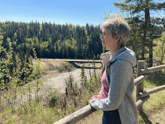 A photo of Brooke looking at a forest.