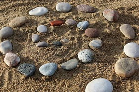 Rocks in a spiral on sand.