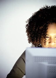 A woman sits in front of a laptop browsing the internet.